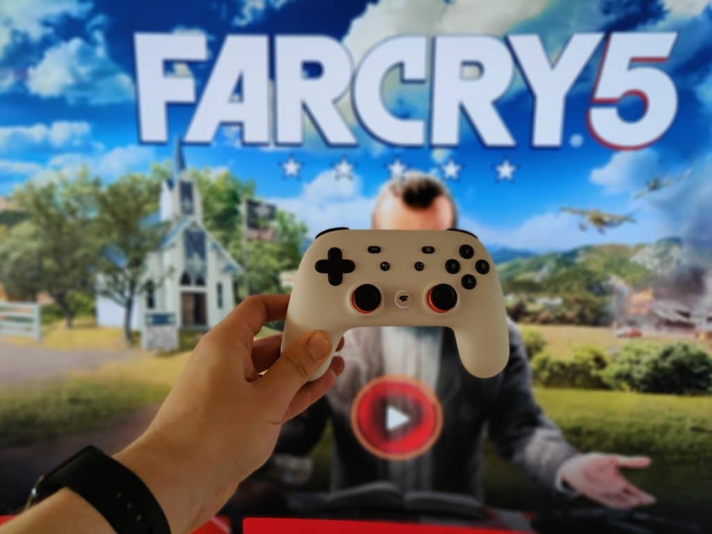 Google Stadia Controller mit Far Cry 5 im Hintergrund